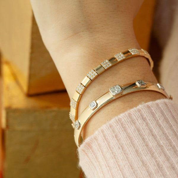 Wrist stack with 14kt gold bangle bracelet and other fine jewelry