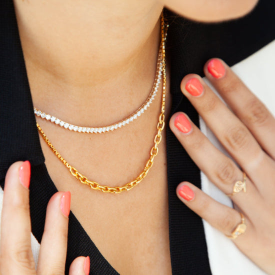 Model wearing a layered look with the 14kt yellow gold mixed link chain necklace in focus