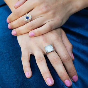Model wearing a bold 18kt white gold cloudy aqua cabochon ring with diamond-set eagle prongs