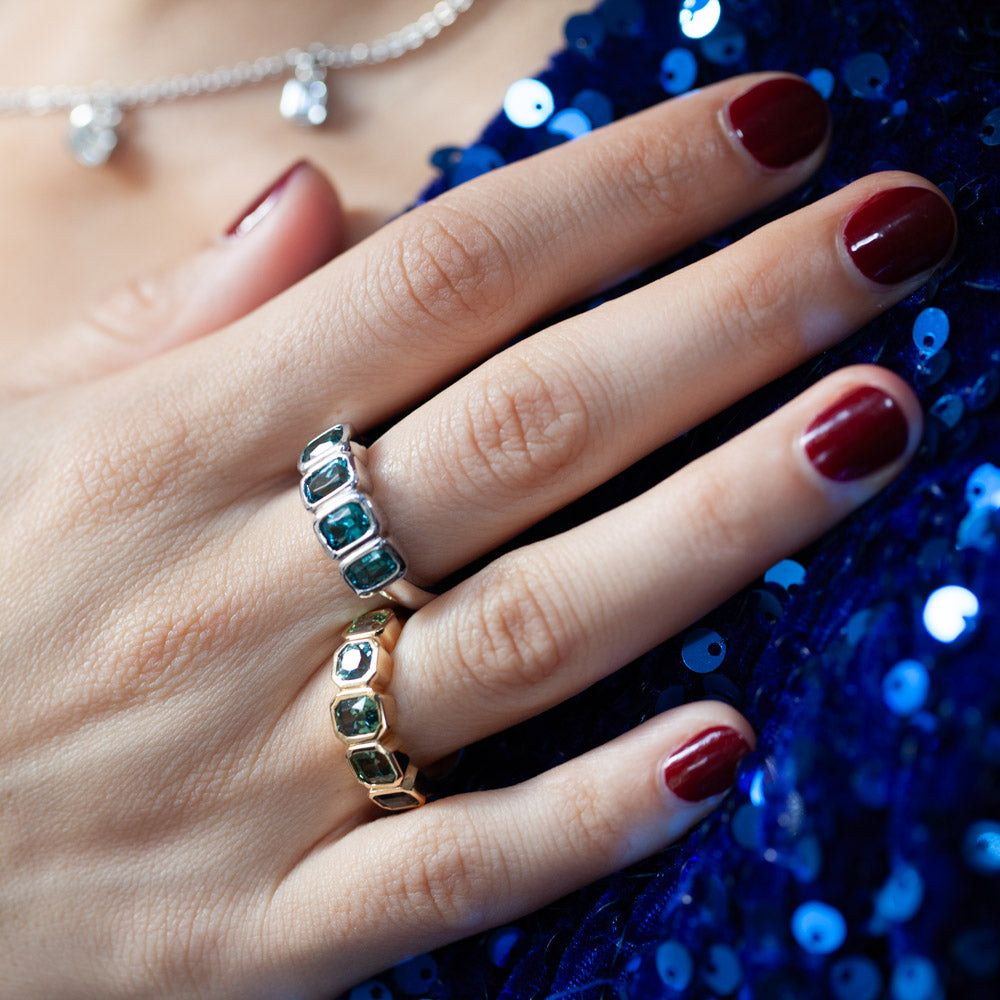 On hand view of 14kt yellow gold bezel-set ring featuring four blue tourmalines totaling 3.98 carats