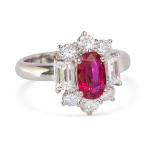 Front view of platinum ring with oval Thai ruby and diamond halo setting