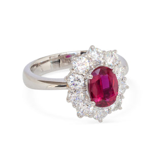 Front angle of platinum halo ring featuring oval ruby and brilliant diamond surround