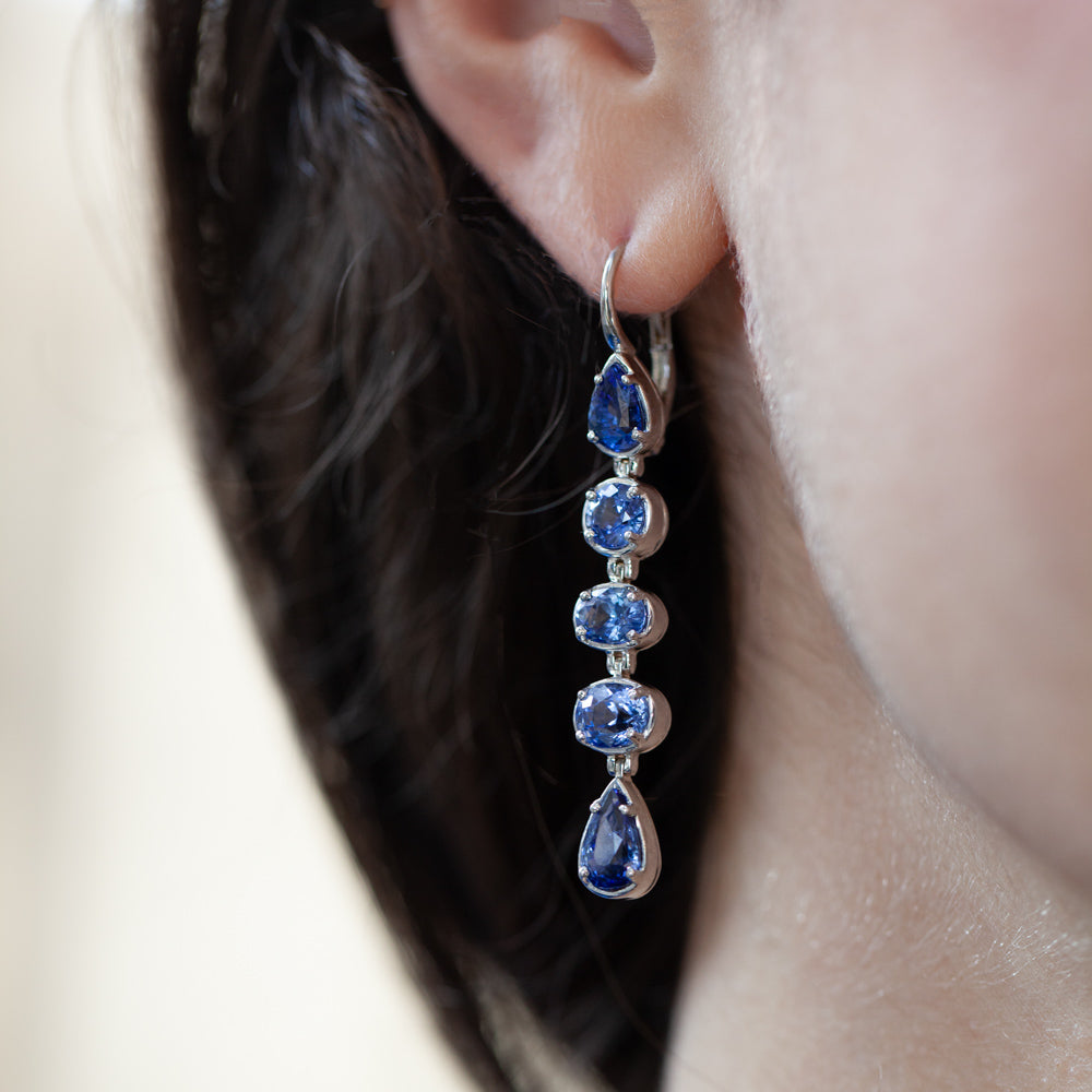 On ear view of 18kt white gold drop earrings featuring 10 Sri Lankan sapphires totaling 9.42 carats