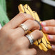 Model hand wearing 14kt white gold scatter band alongside gold scatter ring