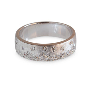 Studio image of a brushed 14kt white gold band with scattered round diamonds