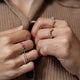 Model wearing 14KT yellow gold pear diamond curved ring on right hand with other gemstone rings