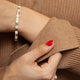 14kt yellow gold and diamond bracelet worn on wrist, styled with a cozy brown sweater