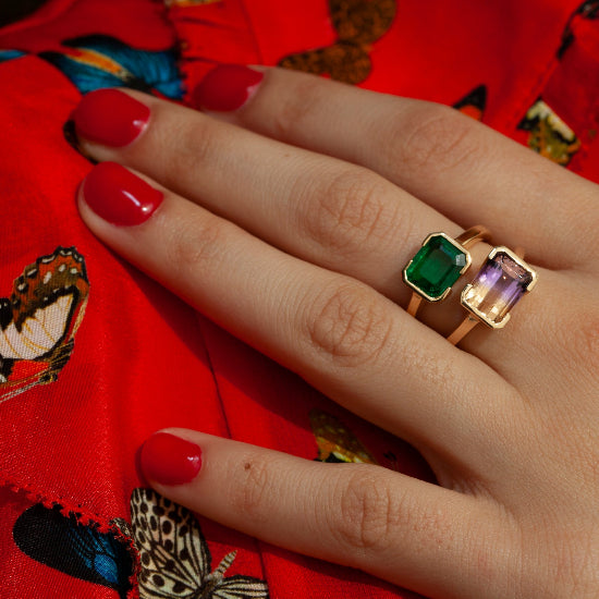 Front view of 18kt yellow gold semi-bezel ring with an emerald cut emerald