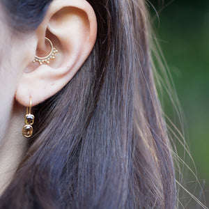 Model wearing 18kt yellow gold brown diamond drop earrings