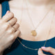Model wearing layered pink sapphire necklace in yellow gold