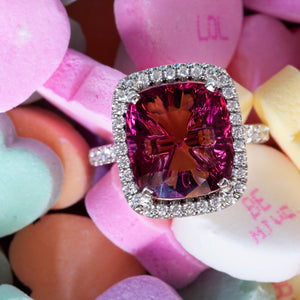  Pink tourmaline and diamond ring displayed on colorful conversation hearts.