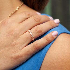Model wearing 14kt rose gold baguette diamond band ring with pastel manicure