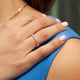 Model wearing 14kt rose gold baguette diamond band ring with pastel manicure